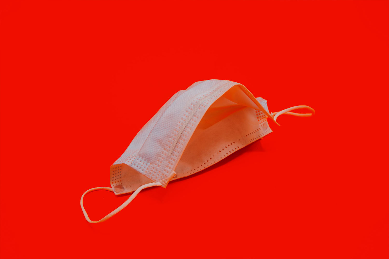 Eine Atemschutzmaske vor rotem Hintergrund