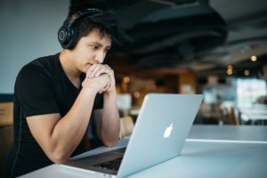 Ein Mitarbeiter sitzt in Arbeit vertieft vor seinem aufgeklappten Laptop