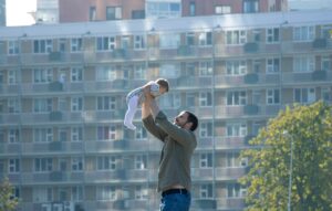Mann hält Baby in die Luft