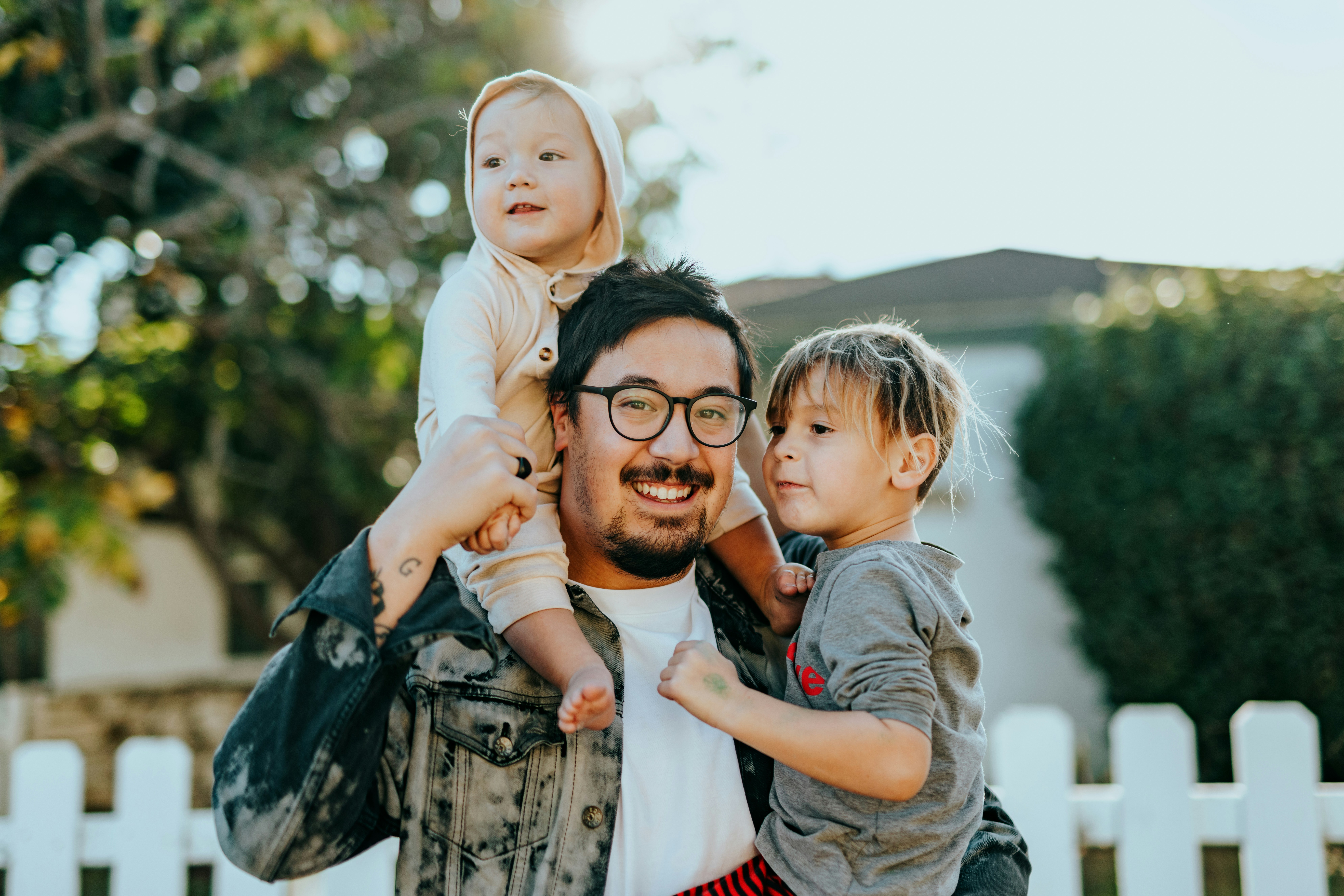 Mann mit zwei Kindern auf dem Arm